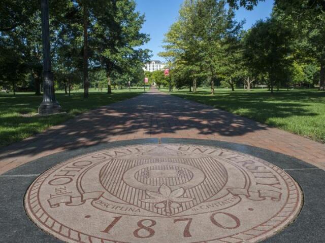 The university's seal embedded in a walkway on the Oval